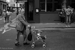 Image of man with baby in pram in black and white