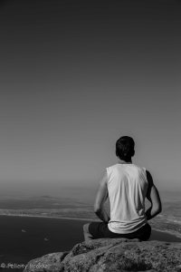Picture of man meditating on top of table mountain, black and white